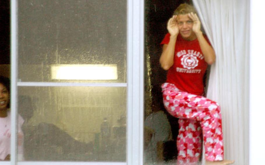 Some Sasebo personnel living off base in older homes were extended an invitation from commander Capt. Michael James to stay on base in bachelor housing. As Typhoon Songda was heavily huffing and puffing Tuesday morning, this young woman stood in a BOH window, trying to get a good look at the wild weather.