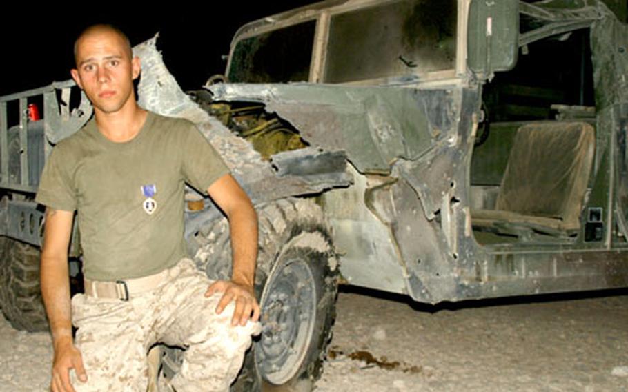 Marine Lance Cpl. Steven Klimtzak of the 4th Civil Affairs Group became the first servicemember of Strike Force — the 2nd Infantry Division’s 2nd Brigade Combat Team — to receive a Purple Heart in Iraq. A bomb hit his Humvee, shown in the background.