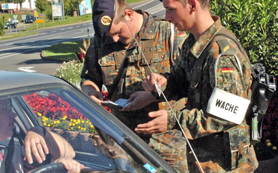 German navy Bundeswehr members check identification before allowing entry at Spangdahlem Air Base’s old main gate. The German navy took over gate control duties at the Germany base from the German army Bundeswehr on Thursday.
