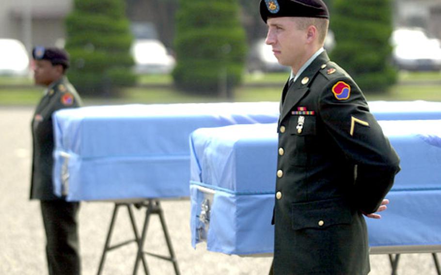 Soldiers stand guard next to the remains of US servicemembers killed in the Korean War.