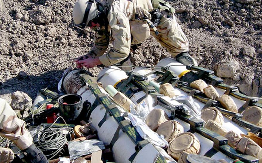 Petty Officer 1st Class Jeffrey Gates disposes of ordnance in Iraq. Gates is now back in Guam with his family.