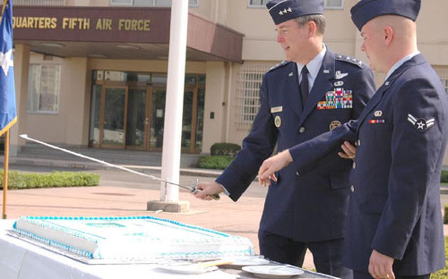 Lt. Gen. Thomas Waskow, left, commander of the 5th Air Force and U.S. Forces Japan, and Airman 1st Class Phillip Haynes of the 20th Operational Weather Squadron take part in the cake-cutting ceremony Friday morning at Yokota Air Base, Japan, which traditionally includes the youngest and most senior airmen present. The event marked the Air Force&#39;s 57th birthday and 63rd anniversary of the 5th Air Force as a numbered unit.