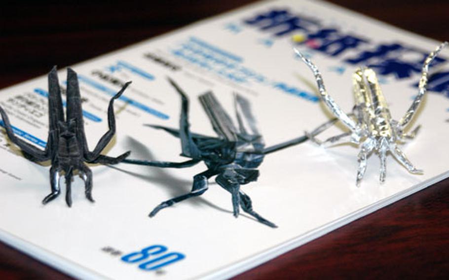 These three mosquitoes are each made from a single piece of paper, 6 inches by 6 inches, and never cut or torn. Origami master Scott Macri, 18, a senior at Ernest J. King High School at Sasebo Naval Base, made the one on the left and the silver one on the far right. The mosquito at center is a cover photograph on a Japanese origami magazine made using the same design pattern. Macri started making various folded paper figures since age seven, when his father, Cmdr. Paul Macri, gave him his first basic origami instructional book.