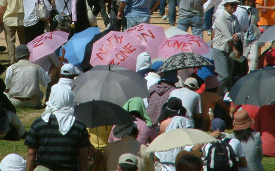 Some umbrellas used to escape from Okinawa&#39;s blazing midday sun carry mesages, such as these urging Ginowan city become a "No Fly Zone."