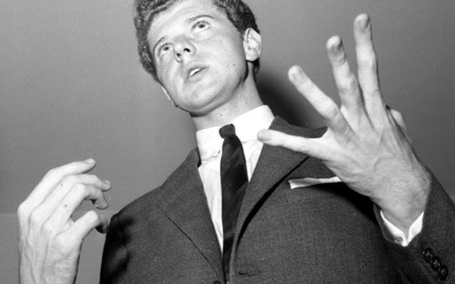 Van Cliburn gestures as he talks to reporters upon his arrival at Heidelberg, Germany, on August 18, 1958.