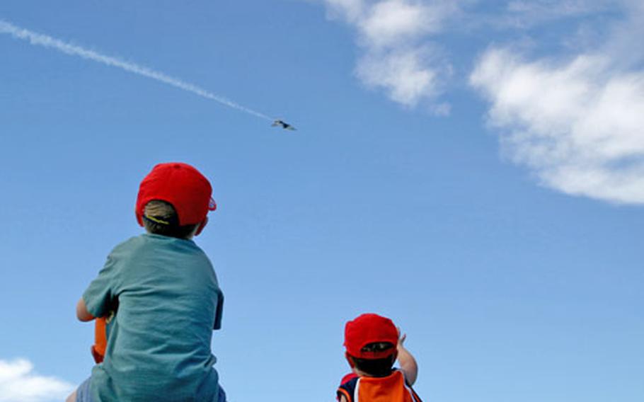 Hayden Froehlich, 5, left, was among the children using the shoulders of adult friends and parents to get a bird&#39;s-eye view of the Thunderbirds practice show on Saturday. Providing Hayden&#39;s perch was his dad, Maj. Eric Froehlich.