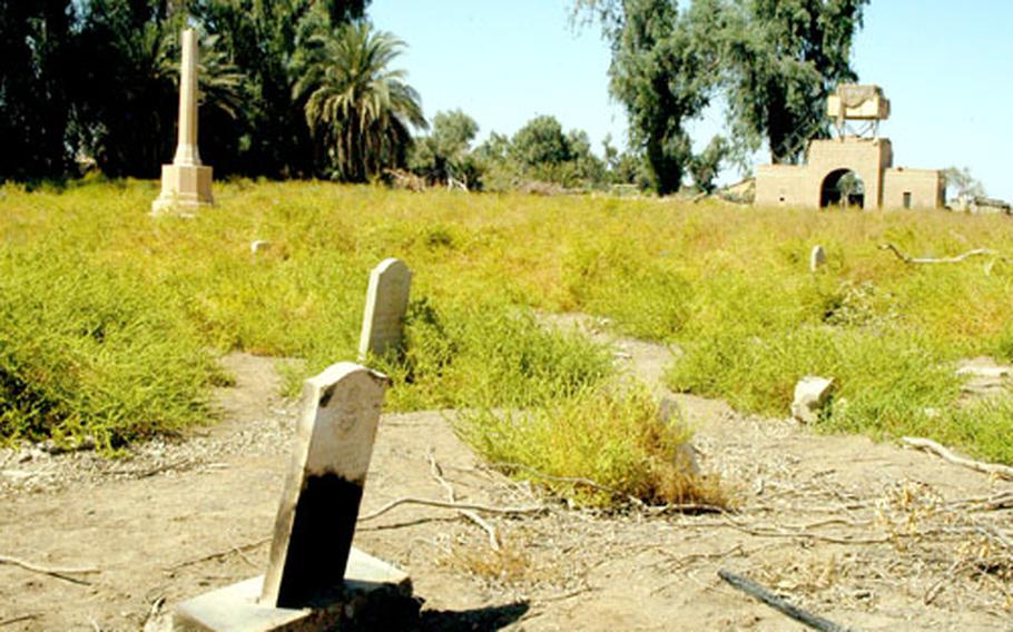 A cemetery for British servicemembers — many who died fighting the Iraqis during World War II — lies in disrepair after having been long abandoned at Camp Habbaniyah, Iraq, a former British base. Old photographs show the large monument to the left of the picture with a cross on top of it and tall trees growing amongst the headstones.
