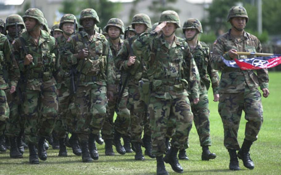 2nd Infantry Division soldiers march in the "pass in review" Tuesday as Maj. Gen. George A. Higgins assumes command.