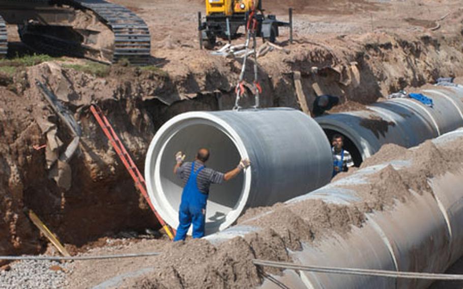 Workers lay drainage pipe at the west end of Ramstein Air Base&#39;s runway in a 15-foot trench Air Force officials called "the big ditch." The ditch is part of a $2 million project to repair the runway.