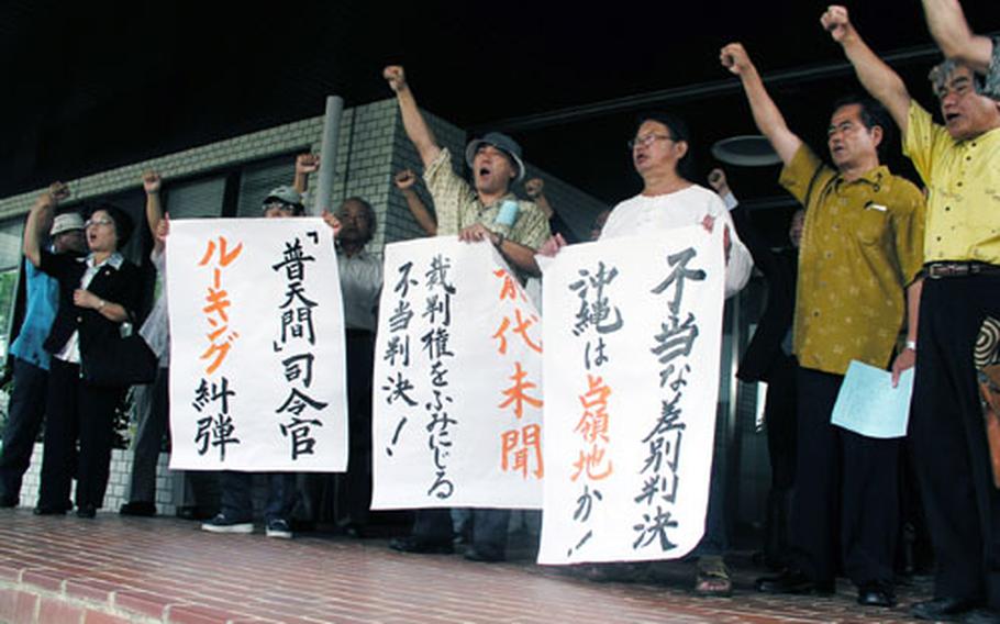 Ginowan residents and their supporters stage a brief protest rally Thursday outside the Okinawa City branch of the Naha District Court in Okinawa City. They staged the rally after their lawsuit against Col. Richard Lueking, commanding officer of Marine Corps Air Station Futenma, was dismissed.