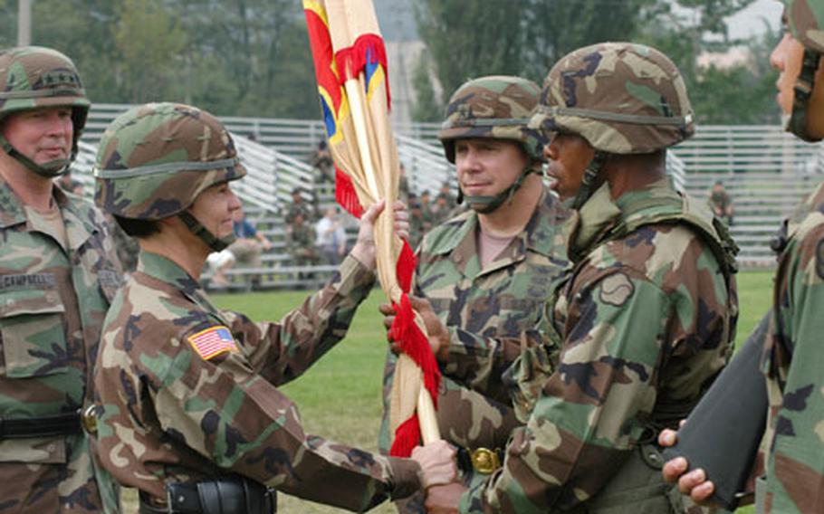 Maj. Gen. Jeanette K. Edmunds, left, takes part in a parade ground ceremony during which command of the unit passes to Brig. Gen. Timothy McHale. (third from left) Friday at Camp Walker in Taegu, South Korea. Handing colors to Edmunds is the unit&#39;s Command Sgt. Maj. Larry C. Taylor. At extreme left is Lt. Gen. Charles C. Campbell, comnmander of 8th U.S. Army, parent unit of the 19th TSC.