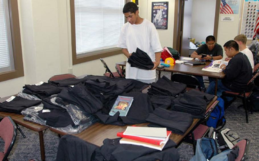 Byrrh Bryant, a 9th grade student in the Navy Junior Reserve Officer Training Corps at Sasebo Naval Base&#39;s Ernest J. King High School, looks for uniform pants in his size Thursday as JROTC cadets were fitted for their uniforms.