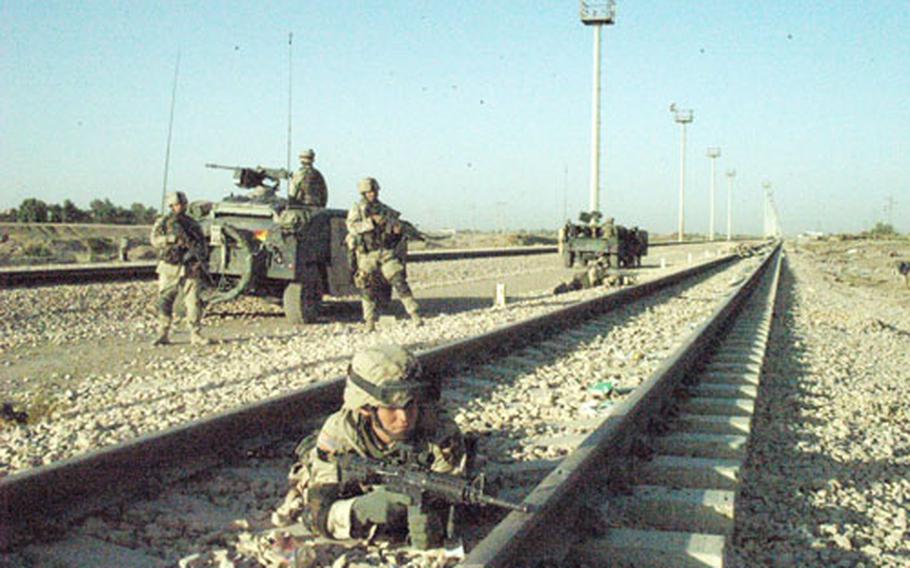 Pvt. Joshua Molt of Company D, 1st Battalion, 503rd Infantry Reigment takes cover along a railway track in Ramadi, Iraq, during fighting with insurgents Thursday.