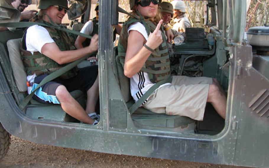 Members of the rock band Puddle of Mudd don body armor and climb into a Humvee as they get a lift to their concert for the troops at FOB Speicher last Sunday. At least 1,500 soldiers attended the show.