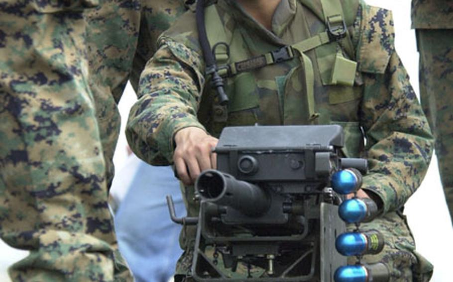 Pfc. Steven Nguyen pulls the handle of an MK-19 automatic grenade launcher during a briefing for the weapon Friday during the Cloud Warrior 2004 exercise at Camp Fuji. Members of Marine Wing Support Squadron 171 from Iwakuni Marine Corps Air Station this week are wrapping up the exercise.