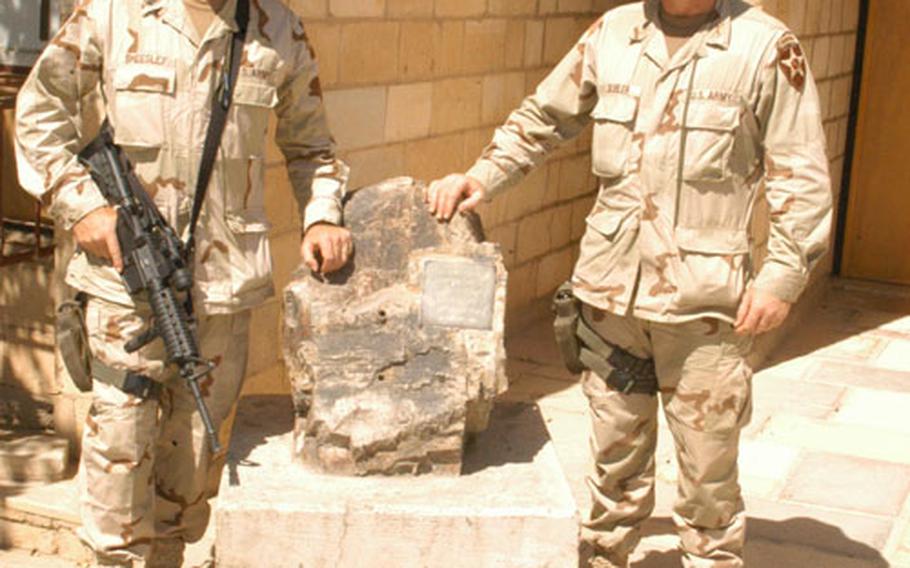 1st Battalion, 503rd Infantry Regiment Command Sgt. Maj. Jeff Sheesley, left, 43, of Alamosa, Colo., and commander Lt. Col. Justin Gubler, 40, of Honolulu, with the rock from Corrigador at Camp Habbaniyah, Iraq.