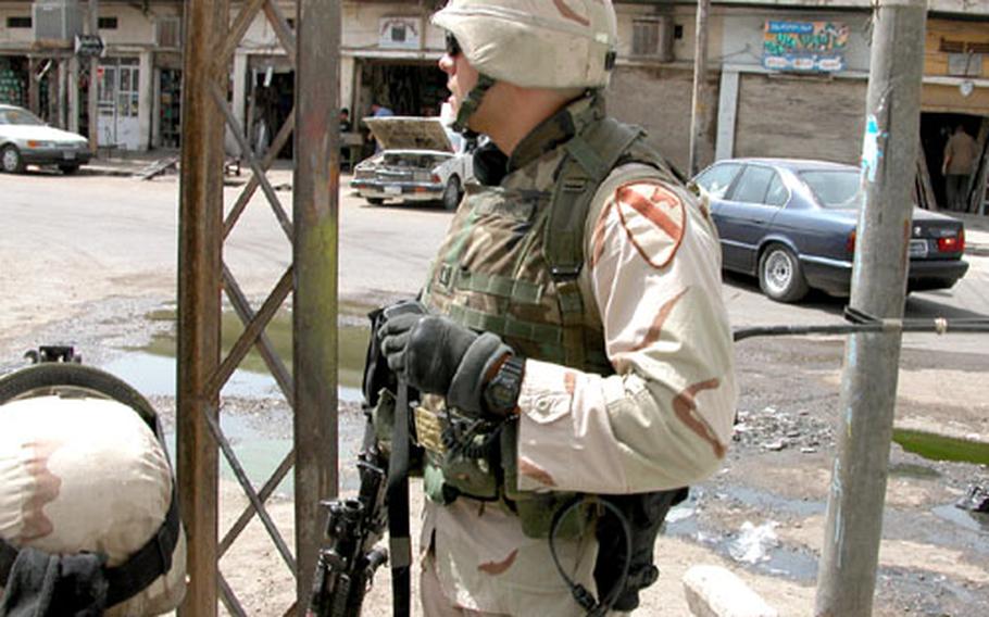 Capt. Chris Ford, commander of Company C, 1st Battalion, 9th Cavalry Regiment, tries to discern the direction of a volley of gunfire as he prepares to lead a foot patrol Sunday on Haifa Street in Baghdad.
