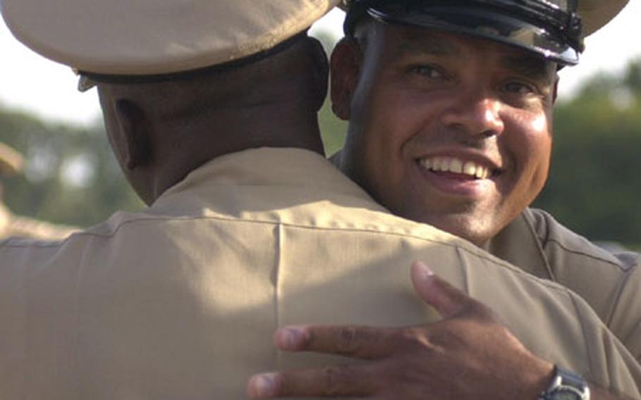 Chief Petty Officer Angel Rivera hugs another chief after a pinning ceremony Wednesday at Naval Station Rota, Spain. The ceremony for 13 sailors tapped for the chief petty officer rank had been postponed as the result of "inappropriate actions" at an initiation function on base Sept. 9.