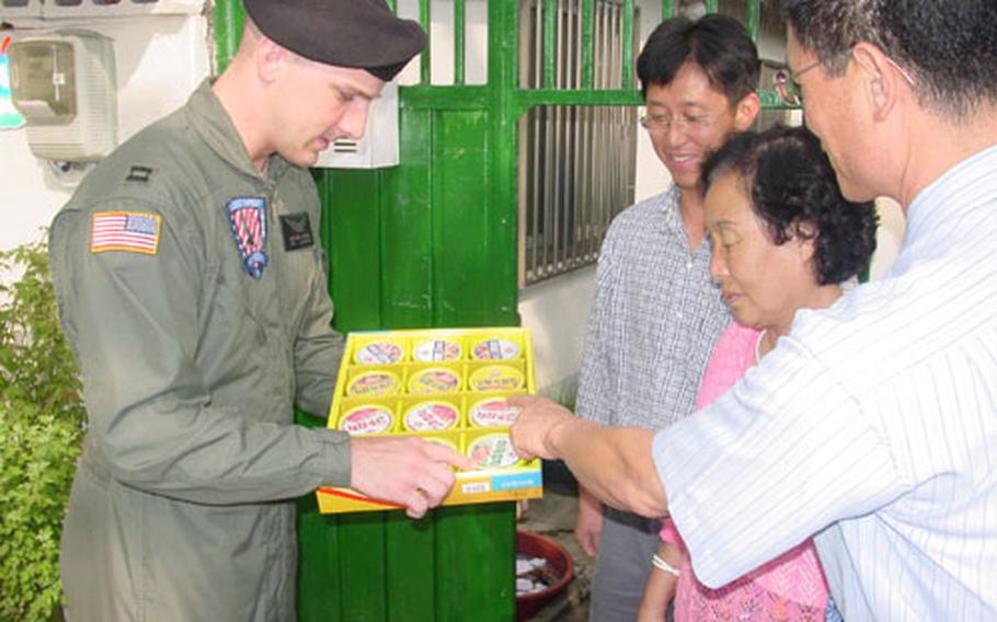 Capt. Matthew J. Bowman, commander of the Walker Army Heliport in Taegu, South Korea, explains the content of a Chusok gift set given to local residents living adjacent to the heliport Friday. The Army&#39;s Area IV Support Activity has given out gift sets to local residents for seven years. Chusok is one of Korea&#39;s major annual holidays and is similar to Thanksgiving in the United States.