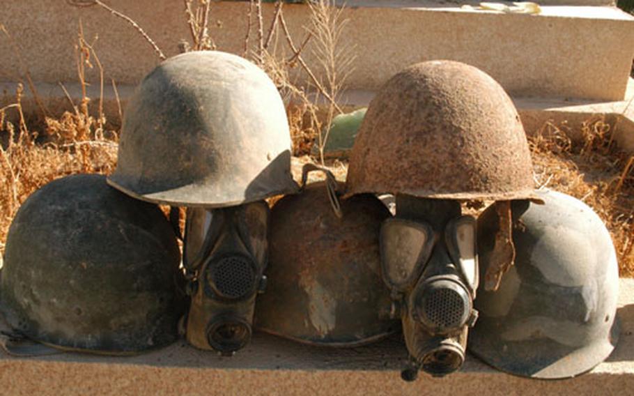 Iraqi helmets, gas masks and uniforms litter the grounds of Camp Habbaniyah, Iraq.