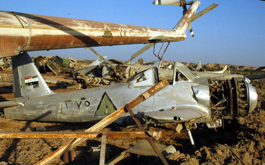 The aircraft graveyard at Camp Habbaniyah, Iraq, has all sorts of machines, including this single-engine prop plane flanked by a pair of helicopters.