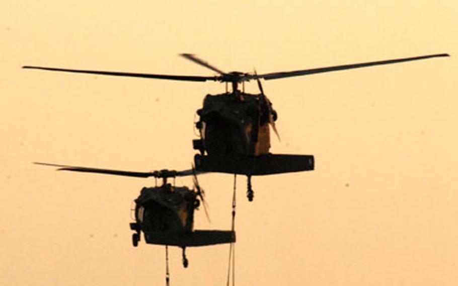 With air assault troops deployed to Iraq, helicopters carry concrete blocks to simulate Humvees and equipment for an infantry company.