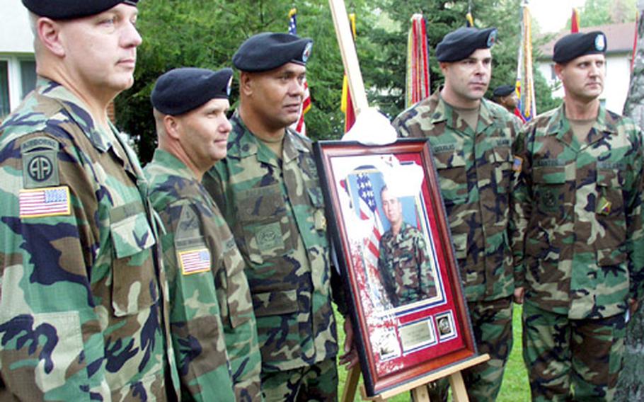 Posing with a picture of 1st Brigade Command Sgt. Major Eric F. Cooke are Command Sgts. Major Michael Bush of V Corps, formerly of 1st Armored Division; Raymond Houston, 1st Brigade; Ioakimo Falaniko, Engineer Brigade; Patrick Douglas, Division Support Command; dnd David Kantor, Division Artillery Brigade. The group attended Wednesday&#39;s dedication of a guest house at Patrick Henry Village in Heidelberg to Cooke, who was killed by a roadside bomb on Christmas Eve night outside Baghdad while visiting his soldiers who were on duty.