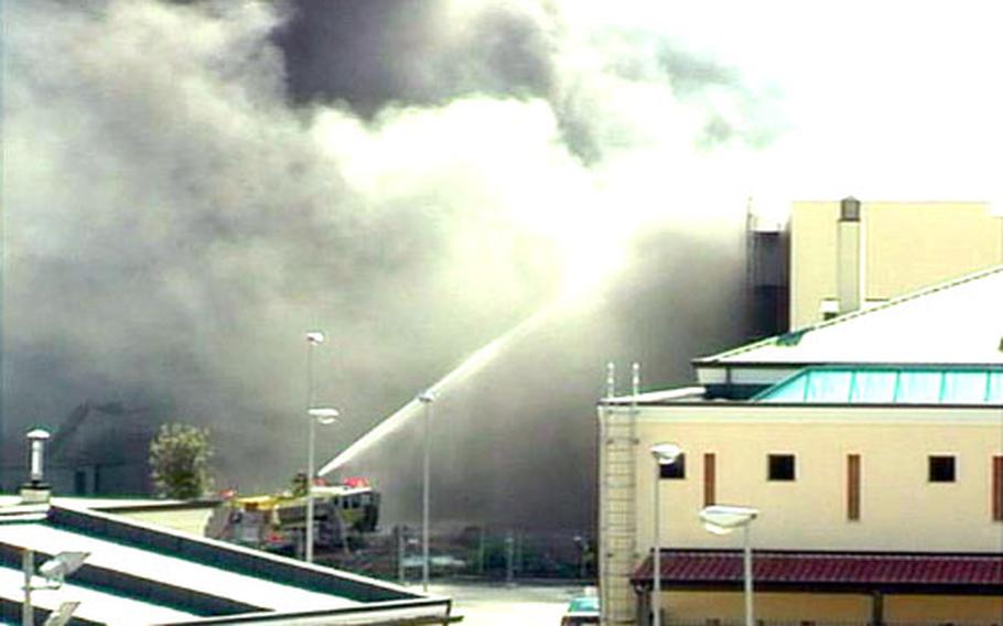 Naval Support Activity Naples firefighters shoot water into the new Navy Exchange and Commissary complex Tuesday afternoon after a worker accidentally started a fire in the facility’s cold storage complex. Firefighters from two Navy stations and local Italian units responded to the blaze, which burned for about two hours.