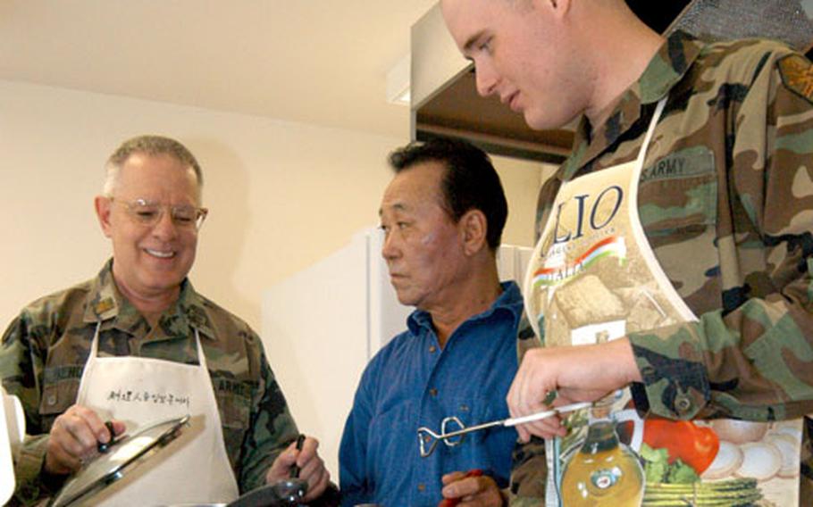 Maj. Richard Bendorf, left, chaplain for the Army&#39;s Area IV in lower South Korea, gives some cooking pointers Friday to Kim Man-cho, center, and Pfc. David White at the Soldiers Memorial Chapel on Camp Walker in Taegu, South Korea. Both Cho and White work with the chapel program. Bendorf, known also as “The Frian’ Friar,” plans to publish a cookbook with favorite recipes.