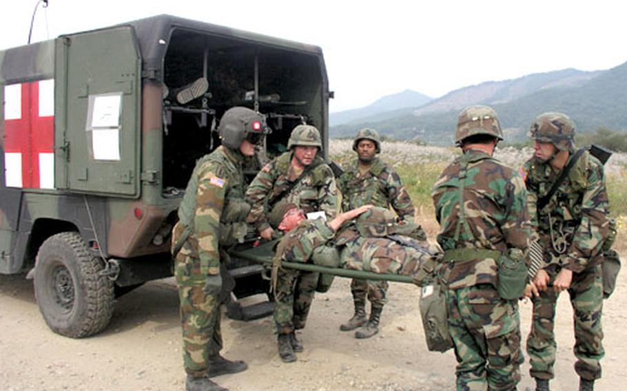 Soldiers move a "wounded" comrade from an ambulance to a waiting dustoff helicopter During battlefield medical evacuation training Thursday in central South Korea.