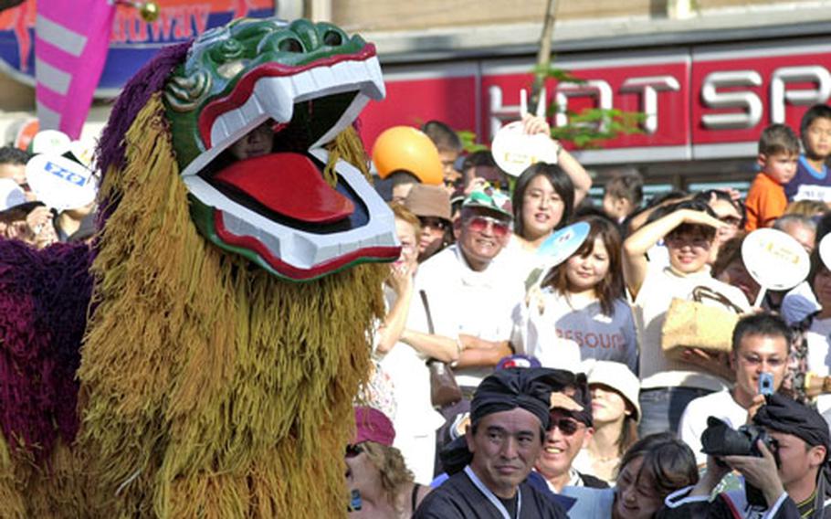 A Shi-Shi dog dance entertains the crowd just before the kick-off of the annual Naha tug-of-war Sunday.