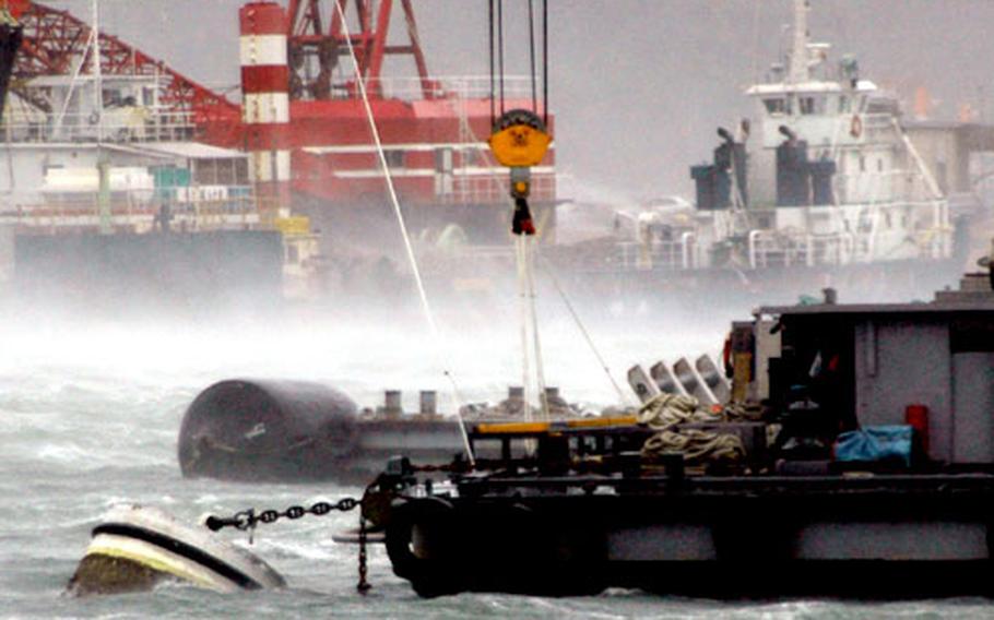 This floating crane platform in the Juliet Basin at Sasebo Naval Base strained against its anchor amid the “smoke” on the water and sea spray caused by Typhoon Tokage’s wind on Wednesday. Although the base did not sustain a head-on onslaught from Tokage, the wind did cause some structural damage to the roof of a warehouse and had the Juliet and India basins in a stir before beginning to ease about noon.