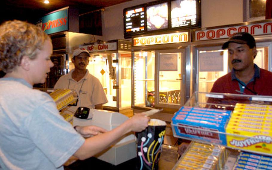 Sgt. Jenny George, with the 557 Medical Company, from Wiesbaden, Germany, buys popcorn at the LSA Anaconda theater. Movie treats, such as buttery popcorn, help make the remote installation feel closer to home for servicemembers.