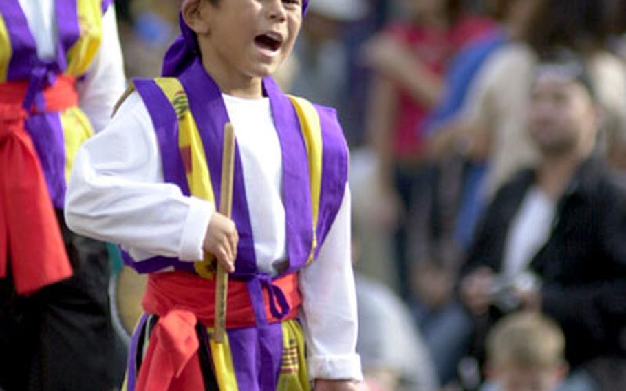A young Okinawan taiko drummer shouts while performing for the crowd during Sunday&#39;s parade.
