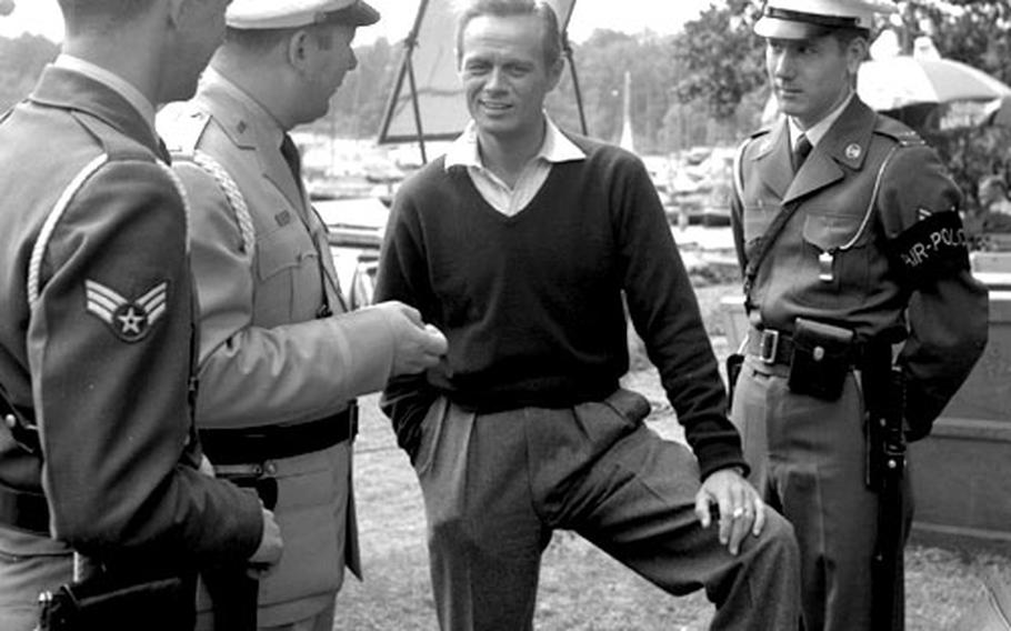 Actor Richard Widmark chats with, left to right, A/1C James Ogilsbie, Lt. John Walsh and Staff Sgt. Luther Perry on the set of ''A Prize of Gold'' in Berlin in July, 1954.