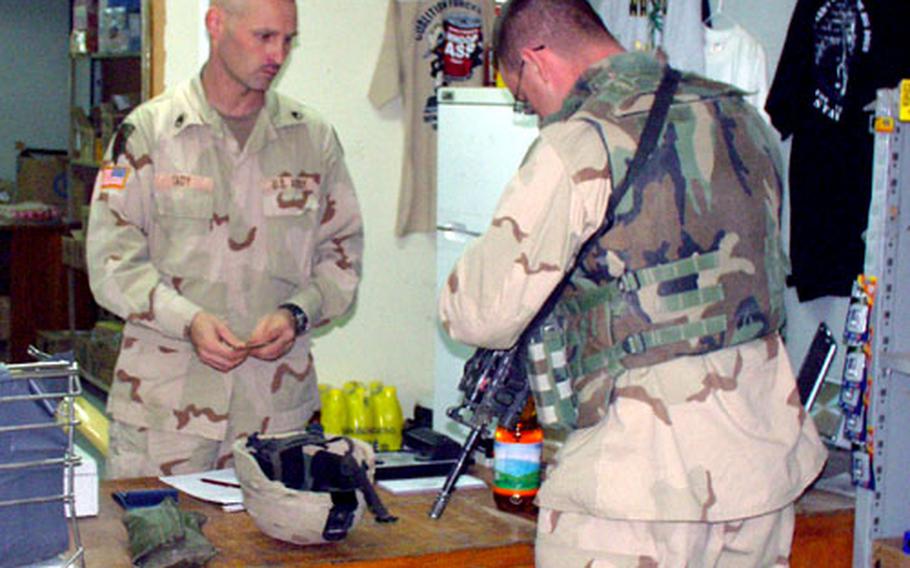 Sgt. 1st Class Clifford Jackson, 28, of the 1st Squadron, 4th Cavalry Regiment, right, makes a purchase at the little post exchange at Forward Operating Base Wilson from the store’s proprietor, Staff Sgt. Richard Cady, 37, of the 121st Signal Battalion.