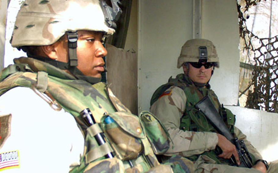 Sgt. Kelly Little, 33, (left) and Sgt. Seth Watson, 32, stand guard along the perimeter of FOB Wilson. Both are members of Battery B of the 1st Battalion, 113th Field Artillery, from the North Carolina National Guard.