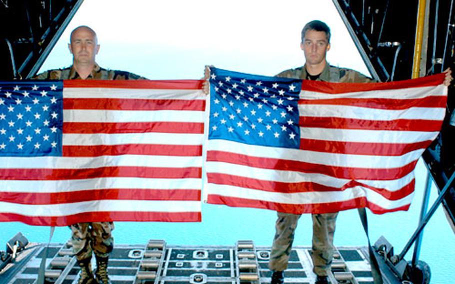 Tech. Sgt. Ron O&#39; Steen, left, and Senior Airman Benjamin Conner, both of the 320th Special Tactics Squadron, Kadena Air Base, pay tribute to Master Sgt. William McDaniel Nov. 8 by flying two American flags over the site in the Philippines where McDaniel and nine other servicemembers died in a helicopter crash on Feb. 17, 2002.