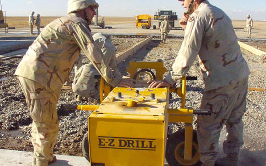 Sgt. Nathan Kaminski, 24, left, and Spc. Brad Thieroff, 21, both of Toledo, Ohio, use a machine to drill holes as part of a $4 million project to repair bomb damage to the runways and taxiways at the Forward Operating Base Speicher airfield in Tikrit, Iraq. Kaminski, a salesman, and Thieroff, a student, both are members of the 216th Engineer Battalion of the Ohio National Guard.