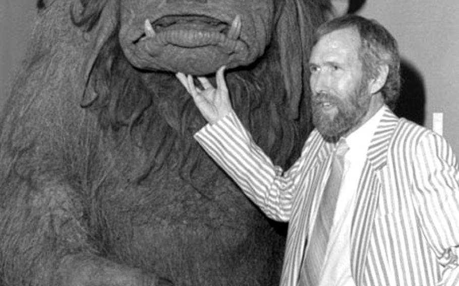 Jim Henson, creator of the Muppets, poses with the character Lado from  at a Muppets exhibit at a Tokyo store.