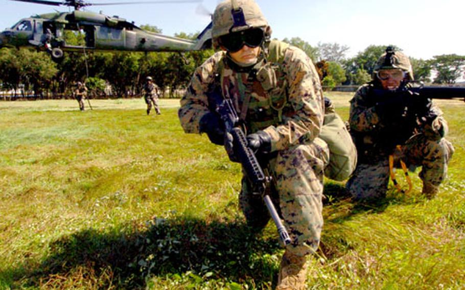 Gunnery Sgt. Paul Vanek, left, and Cpl. David Bustos hold their position during fast-rope training.