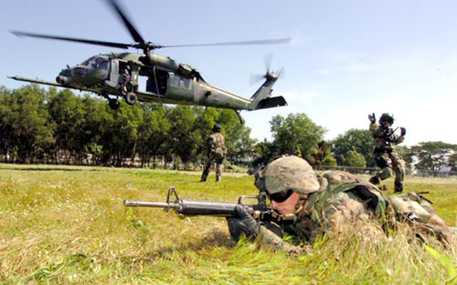 Pfc. Kenneth Carbaugh from the Combat Assault Battalion, 3rd Marine Division holds a defensive perimeter during fast-rope training.