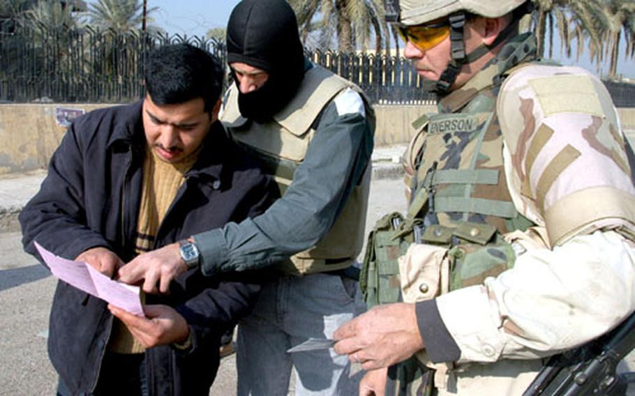 Spc. Jason Enerson of the 58th Combat Engineer Company&#39;s Assault and Obstacles Platoon watches as unit interpreter "Brad Pitt," as he&#39;s called by the soldiers, checks an Iraqi man&#39;s registration aganst his license plate during a search of the man&#39;s car Saturday.