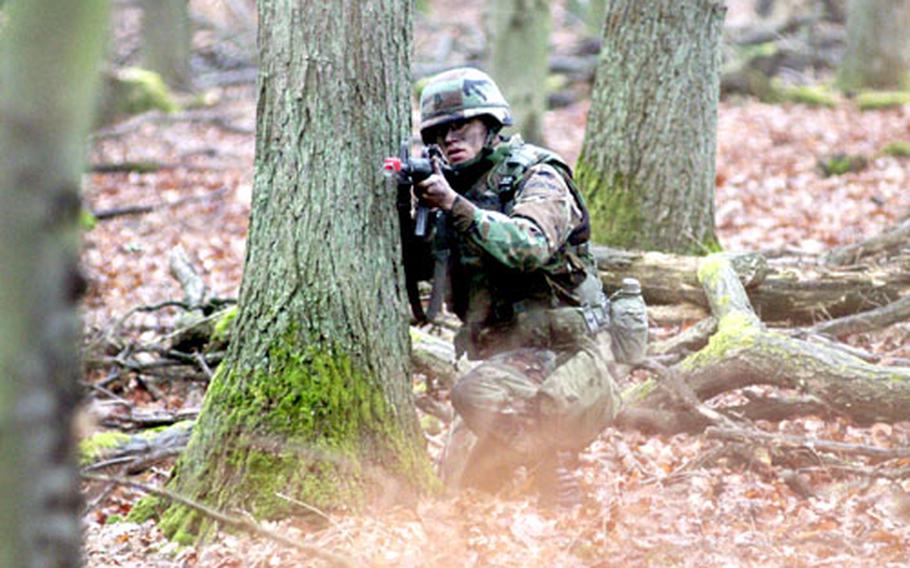 Sgt. Jessy Carr of Battery C, 1st Battalion, 94th Field Artillery Regiment, looks for a sniper while maneuvering through the "move under direct fire" task during the 1st Armored Division&#39;s NCO of the Quarter competition.