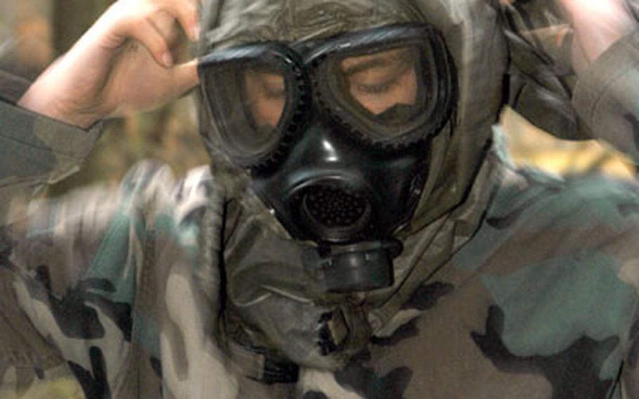 Pfc. Aaron Jewell, of the 69th Chemical Company, dons his nuclear, biological and chemical protection gear, while competing at the 1st Armored Division’s Soldier of the Quarter competition at the Friedberg training area on Wednesday.