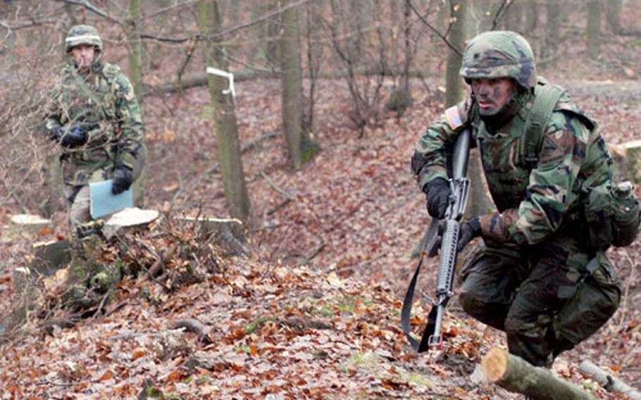 Tester Staff Sgt. Chris Allen, left, watches Spc. Tim Harris, Company C, 1st Battalion, 36th Infantry Regiment, maneuver through the "move under direct fire" task at the 1st Armored Divsion&#39;s Soldier of the Quarter competition.