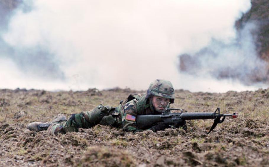 With explosions going off behind him, Spc. Tim Harris, Company C, 1st Battalion, 36th Infantry Regiment, takes cover during the "react to indirect fire" task.