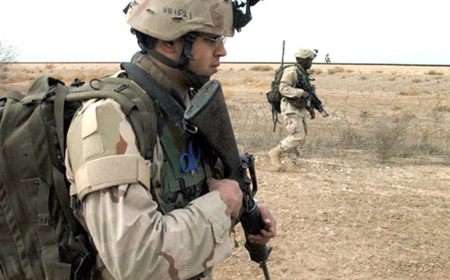 Medic Spc. Angelo Veguilla and other soldiers from Headquarters and Headquarters Company of 2nd Battalion, 14th Infantry Regiment, walk along a road bordering farmers&#39; fields and railroad tracks north of Abu Ghraib as they search for weapons caches. The soldiers from the platoon found a Russian rocket, which had its explosives removed, and two 155mm artillery rounds during their search on Thursday.