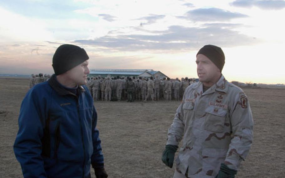 Martin Fano, left, a civilian who acts as the liaison at Aviano Air Base for the Southern European Task Force (Airborne), talks with Maj. Andrew Rohling, executive officer of the 2nd Battalion, 503rd Infantry Regiment, before a jump near Aviano last week.