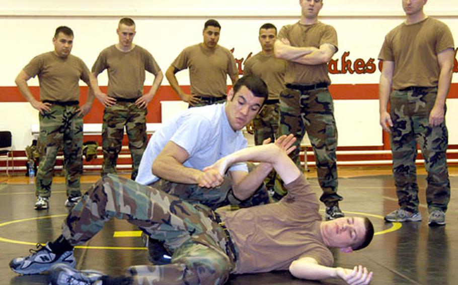Ryron Gracie shows soldiers of the Babenhasuen, Germany-based 1st Battalion, 27th Field Artillery a hold on 1st Lt. Andrew Nilson during hand-to-hand combat training on Wednesday.